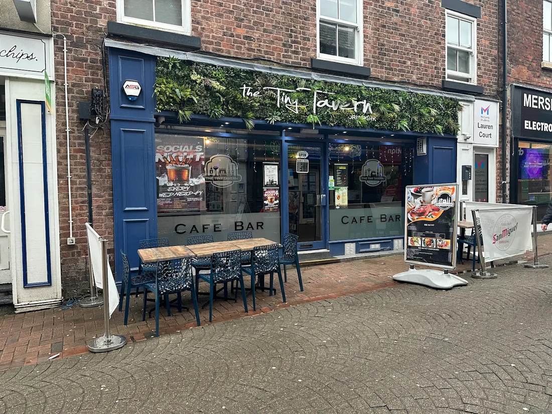The Tiny Tavern's blue shopfront on Burscough Street with outdoor seating