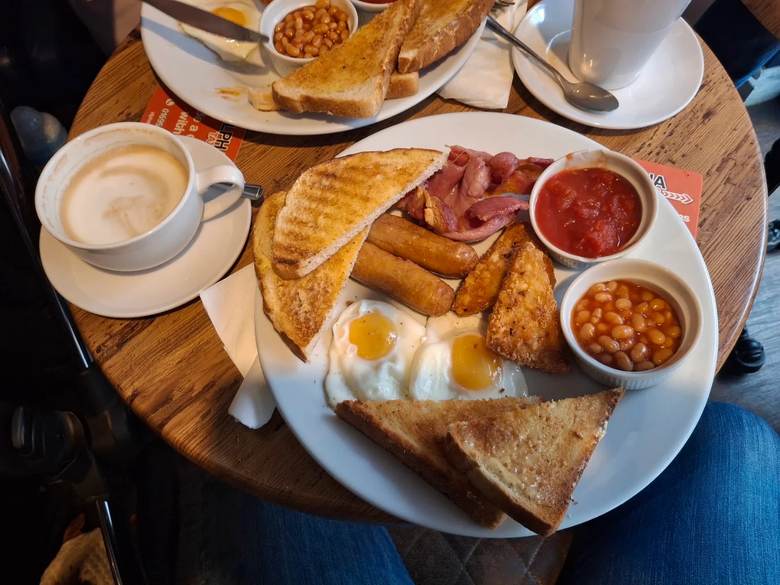 A full breakfast with eggs, bacon, sausage, hash browns, beans and toast